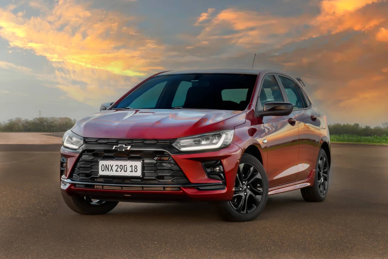 Chevrolet Onix RS 2027 em uma via ao pôr do sol.