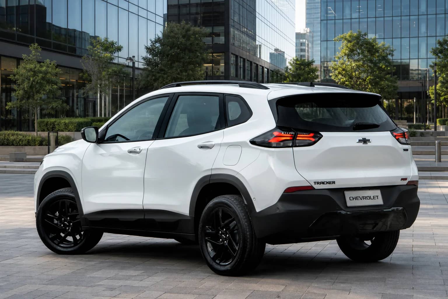 Chevrolet Tracker branco visto de trás e de lado diante de edifícios.