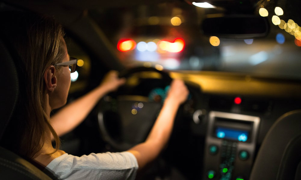 Uma pessoa ao volante de um carro dirigindo dando dicas sobre dirigir à noite