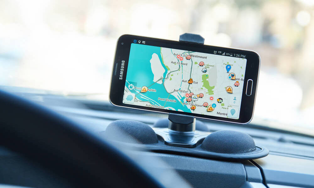 Celular com GPS apoiado no painel do veículo.