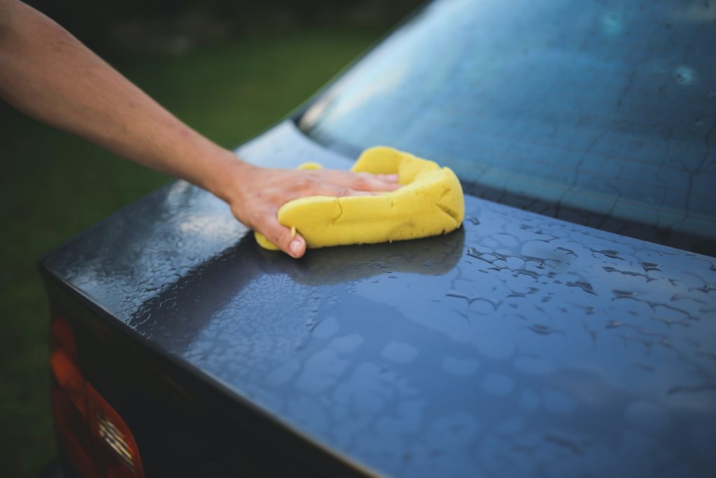 pessoas limpando o carro com esponja