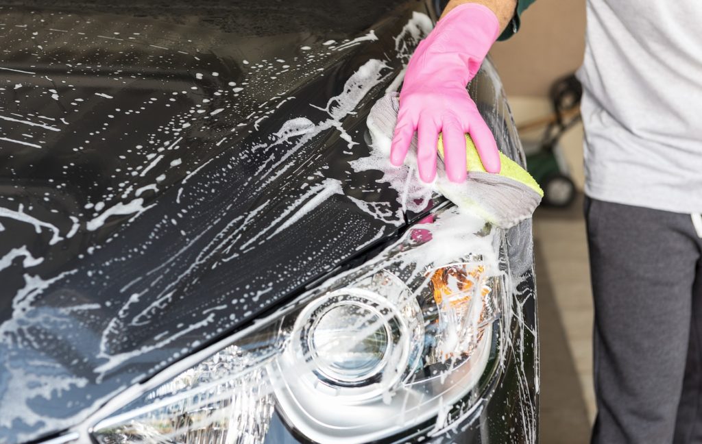 Homem lavando carro com equipamentos adequados