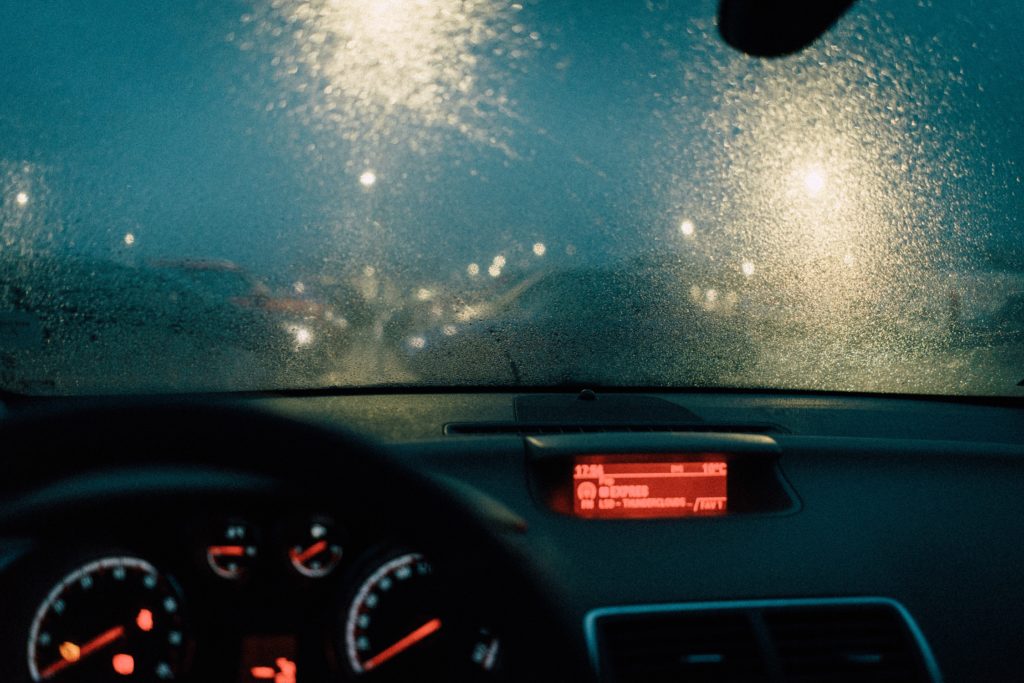 Imagem interior de um veículo dirigindo na chuva.