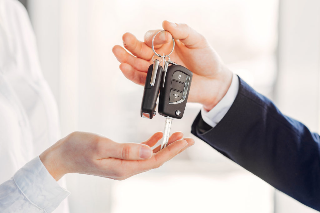 Mãos ao redor de uma chave de carro, um par de mãos está segurando a chave.