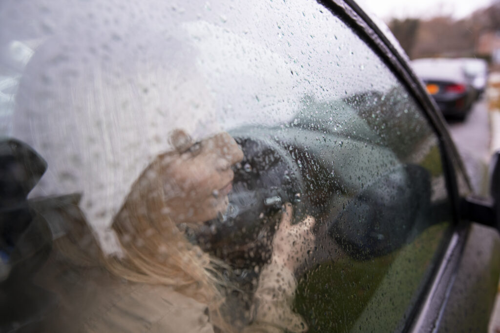Mulher dirigindo na chuva.