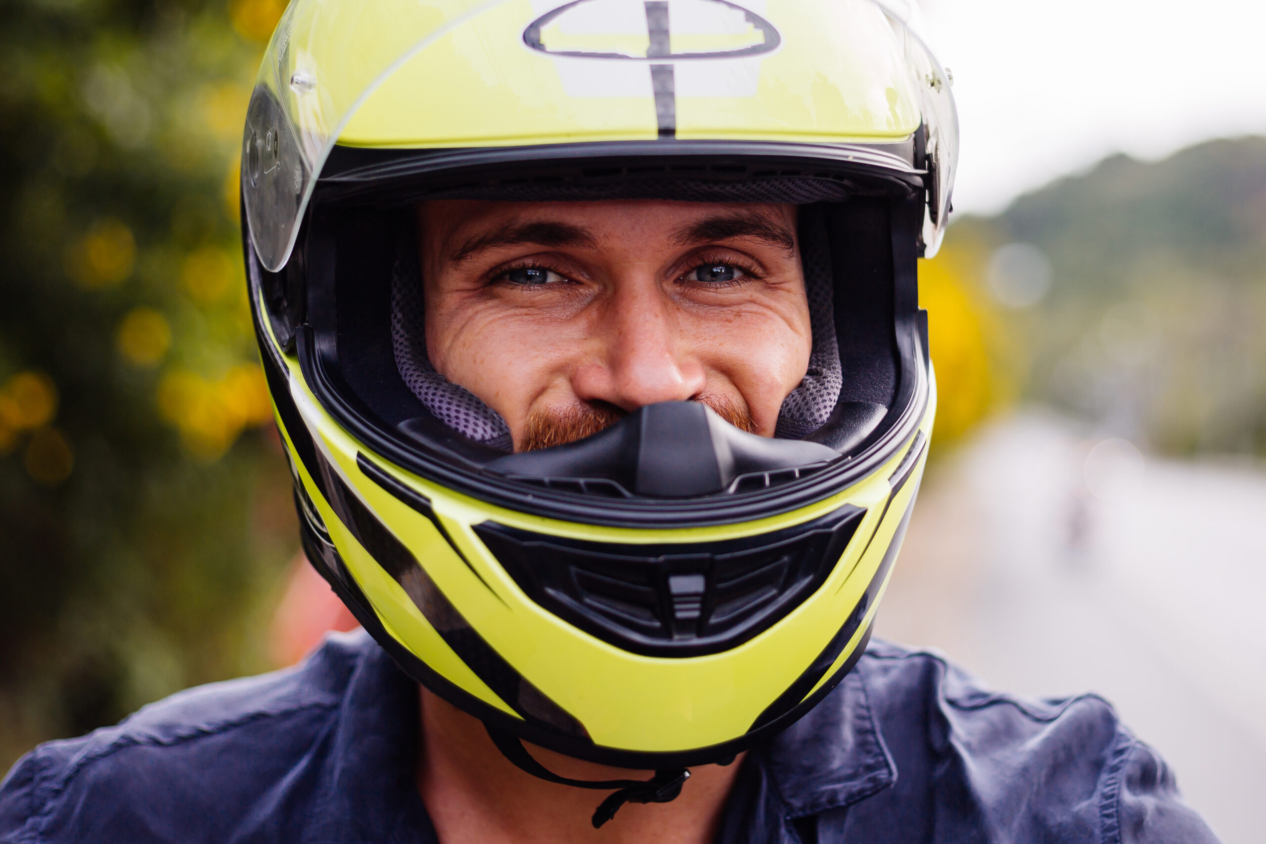 Motociclista usando capacete amarelo.