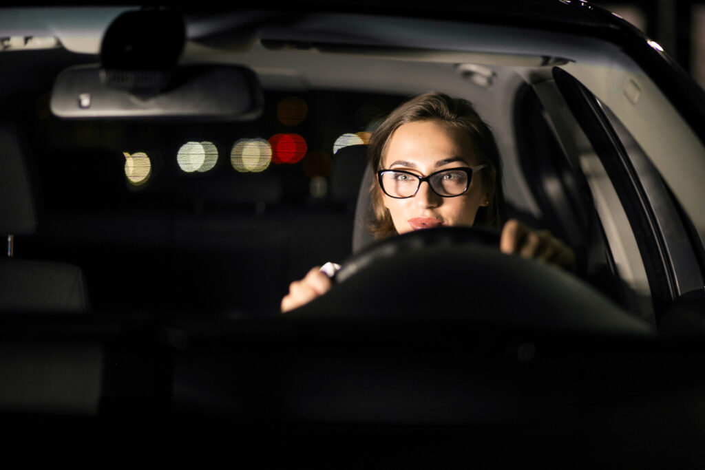 Mulher dirigindo veículo a noite.