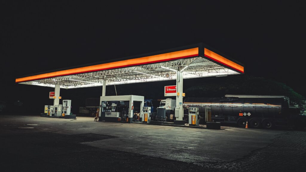 Posto de gasolina, á noite, vazio e com as luzes acesas.